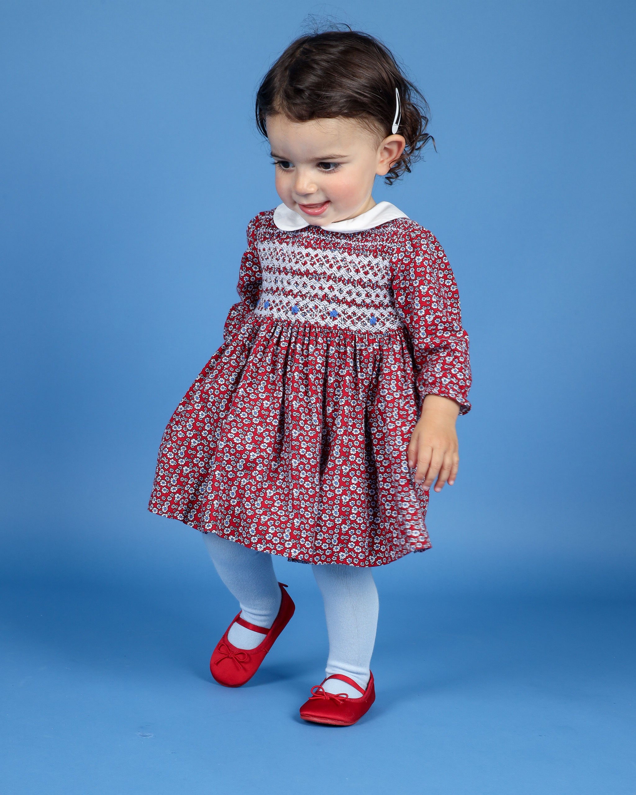 baby in red floral smock dress