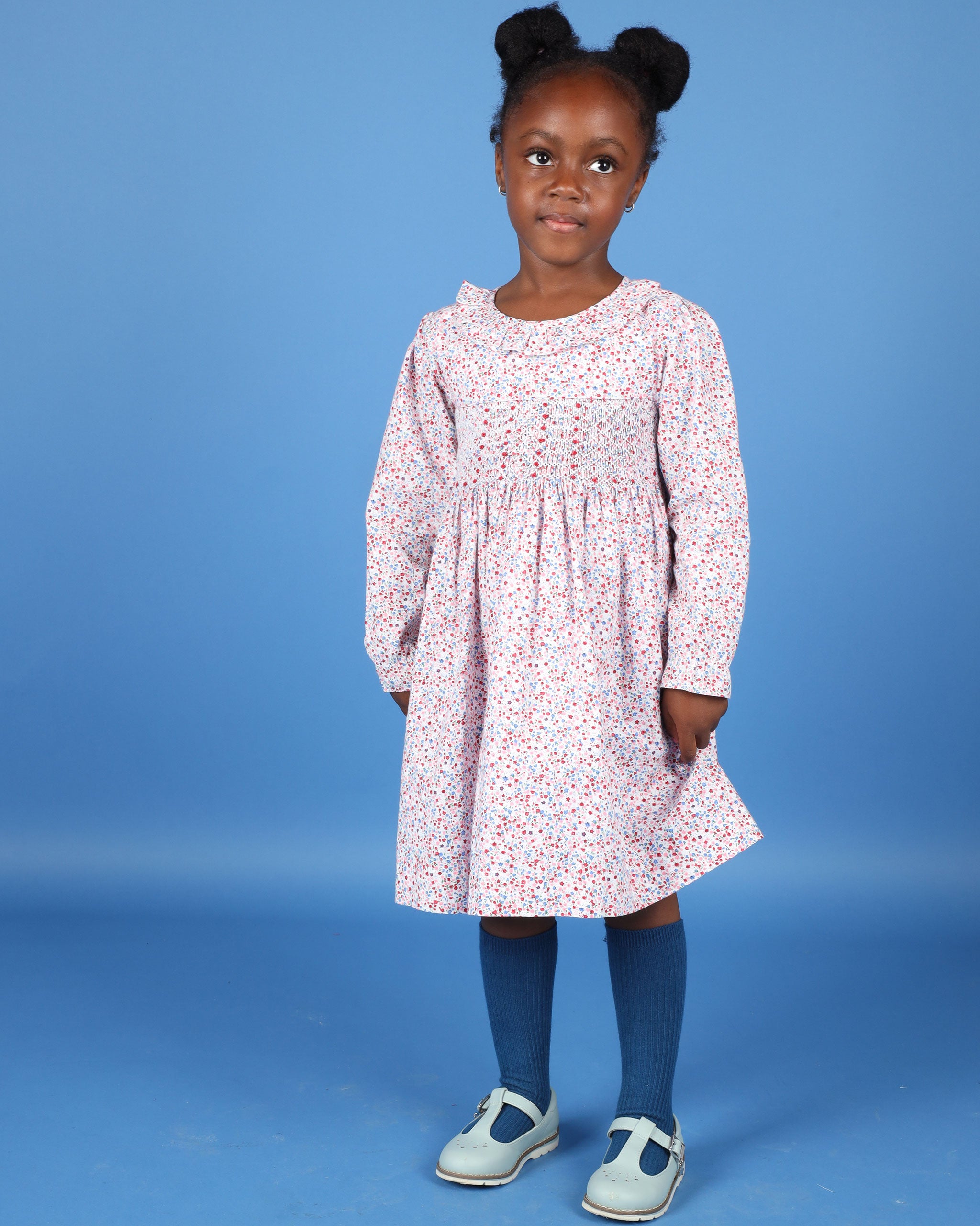 girl in pink floral dress with smocking