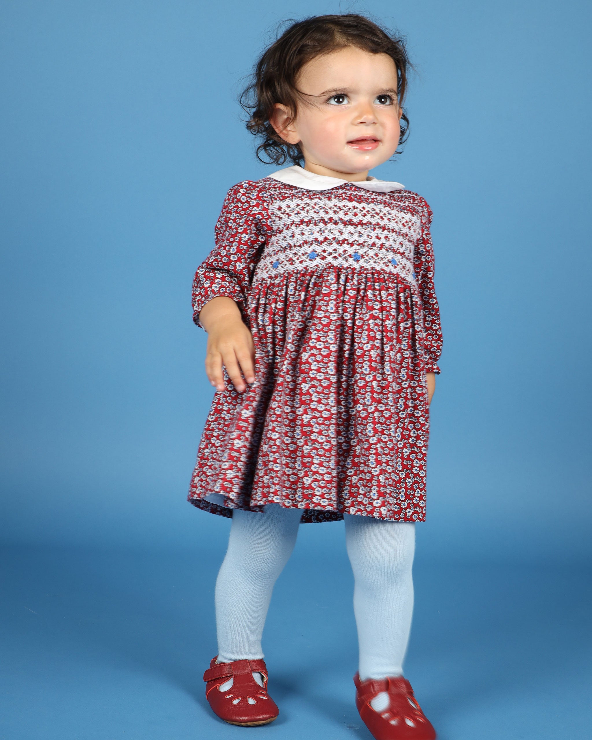 toddler in festive red dress with smocking and embroidery