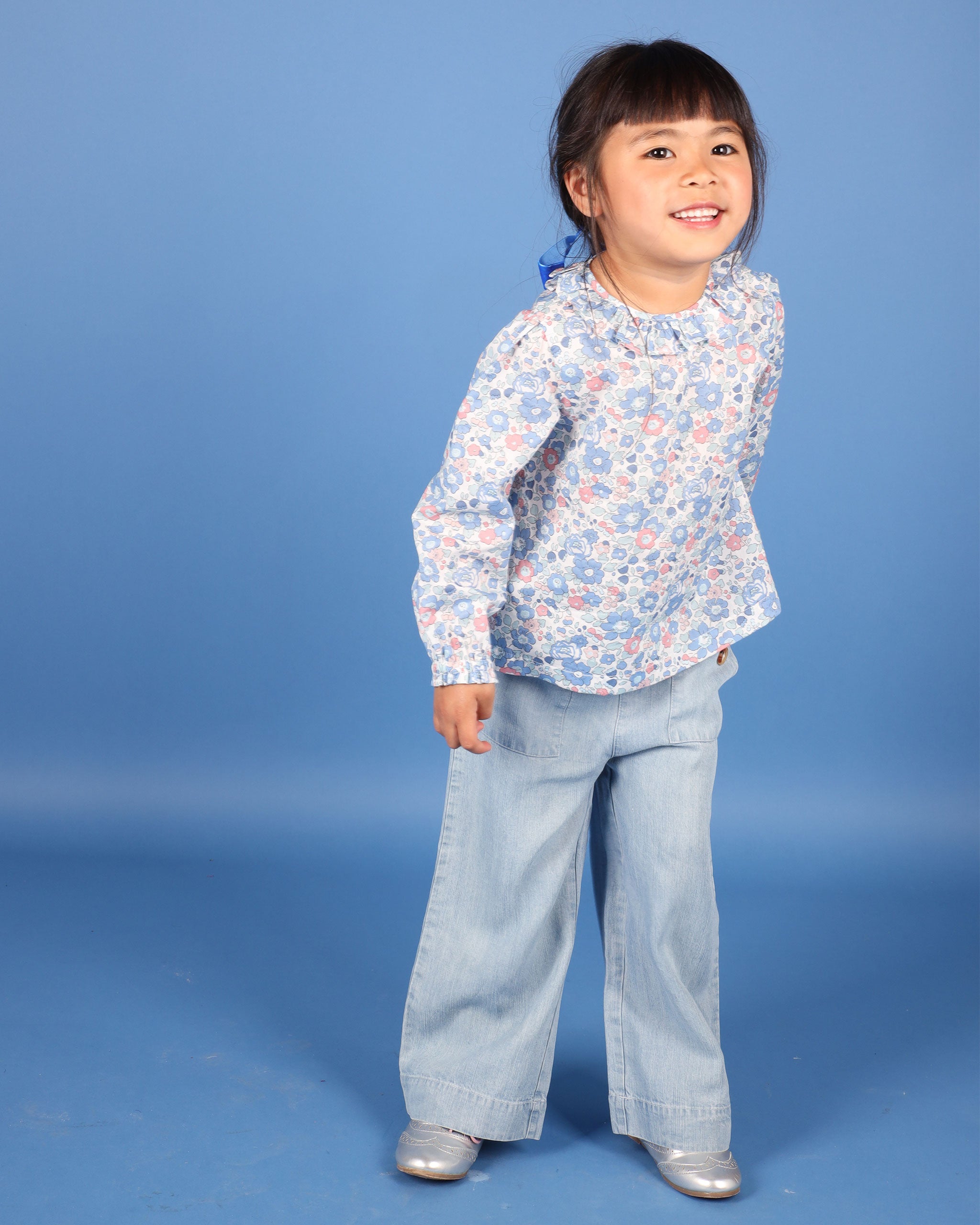 girl in blue floral blouse, Liberty Betsy fabric, frill collatr