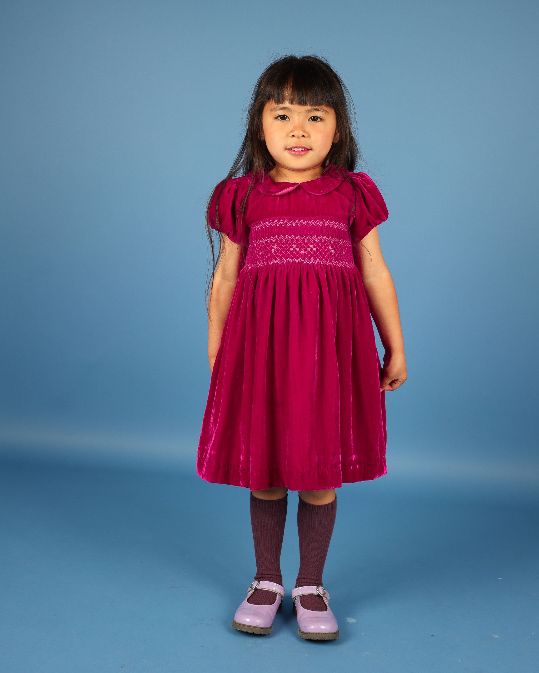 girl in hand-smocked party dress made from pink velvet