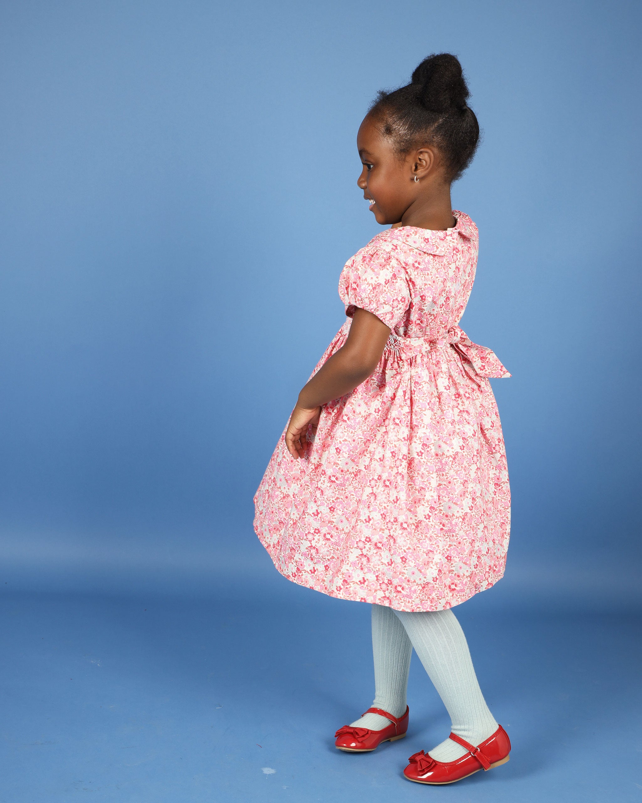 girl in smocked dress twirling 