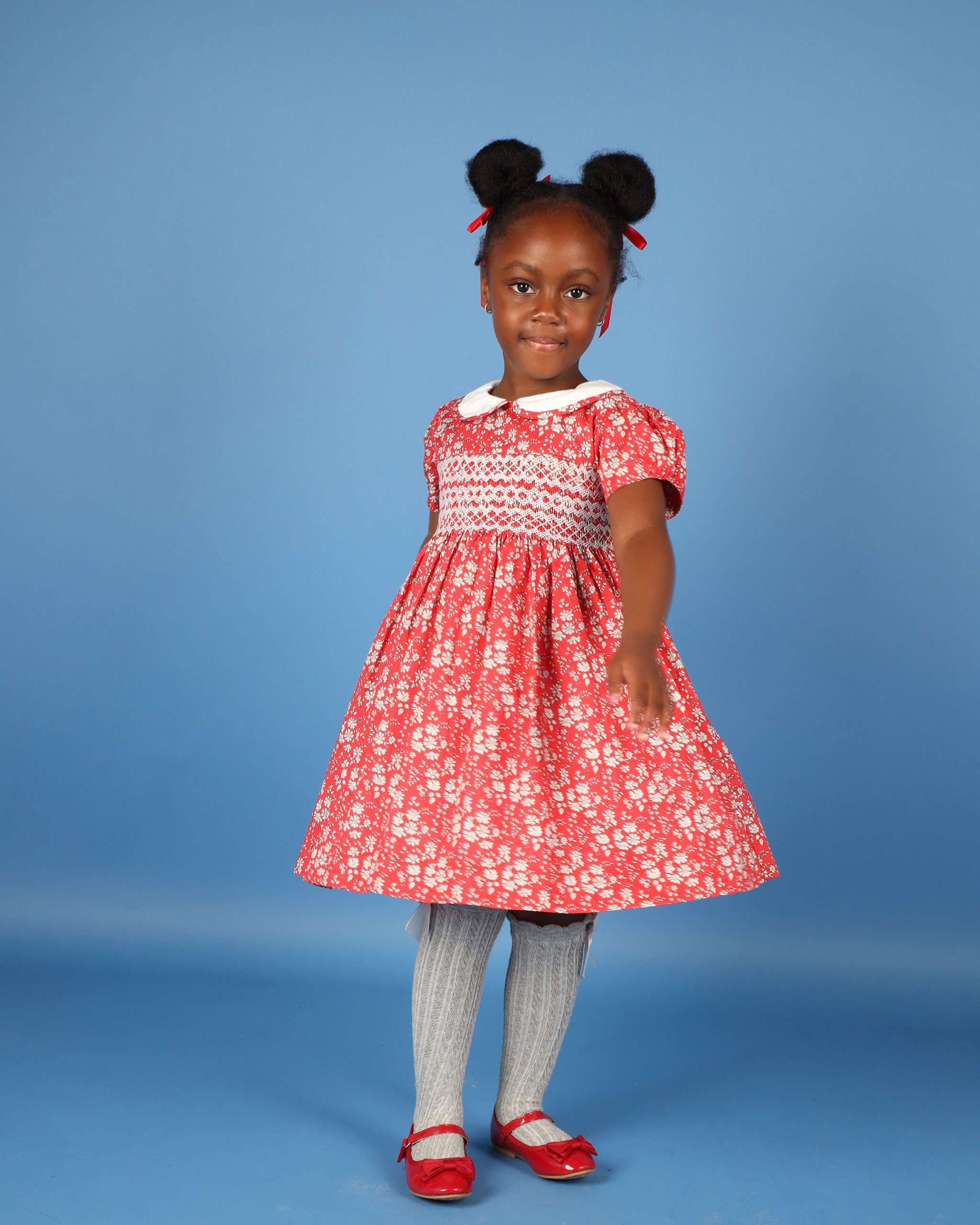 girl in red and white smocked dress made from Liberty fabric