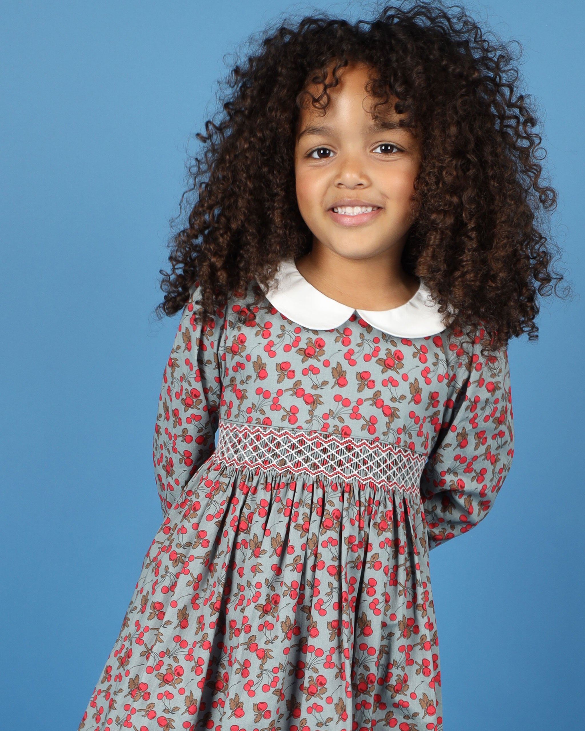 girl in cherry print smocked dress