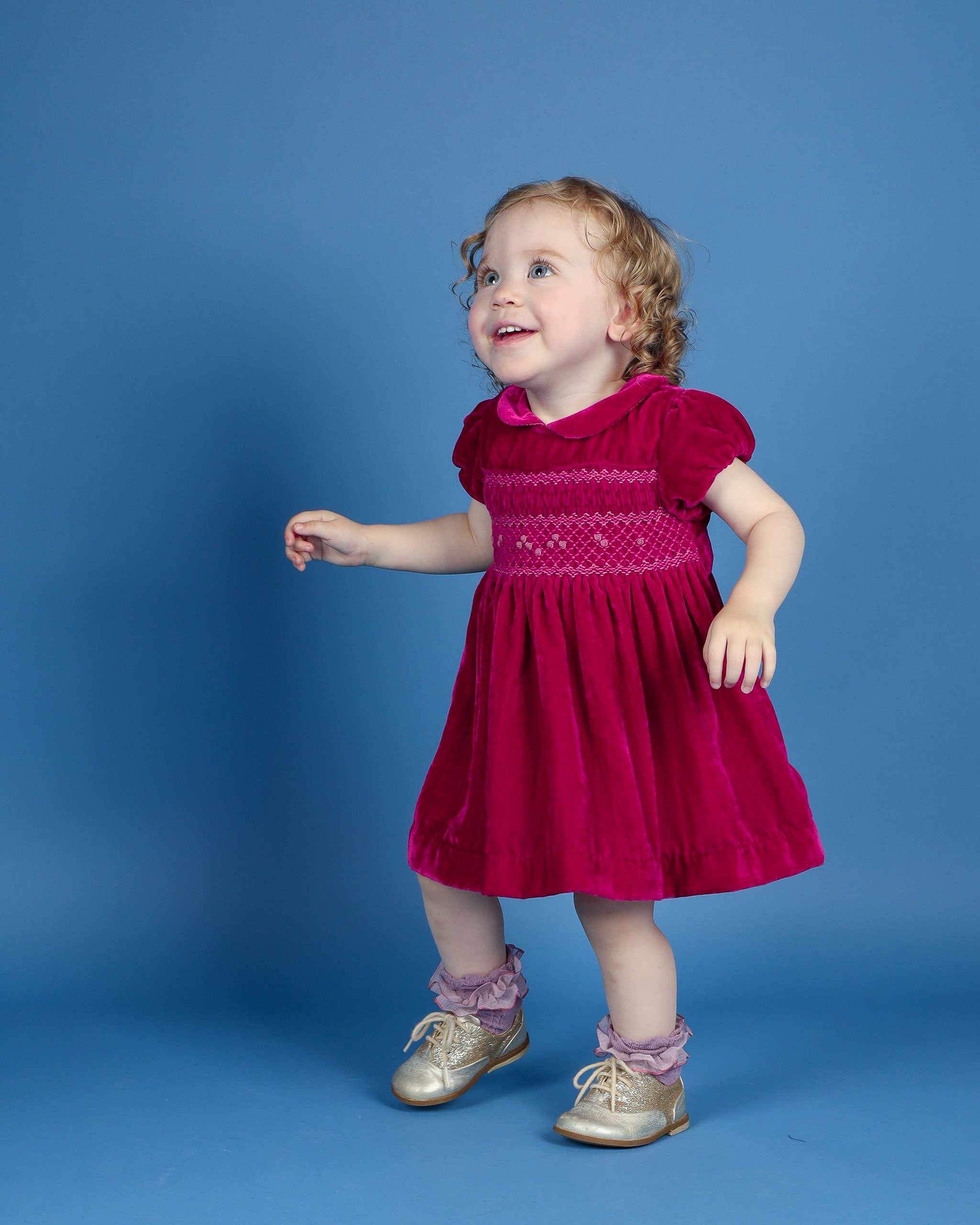 baby in velvet party dress with smocking