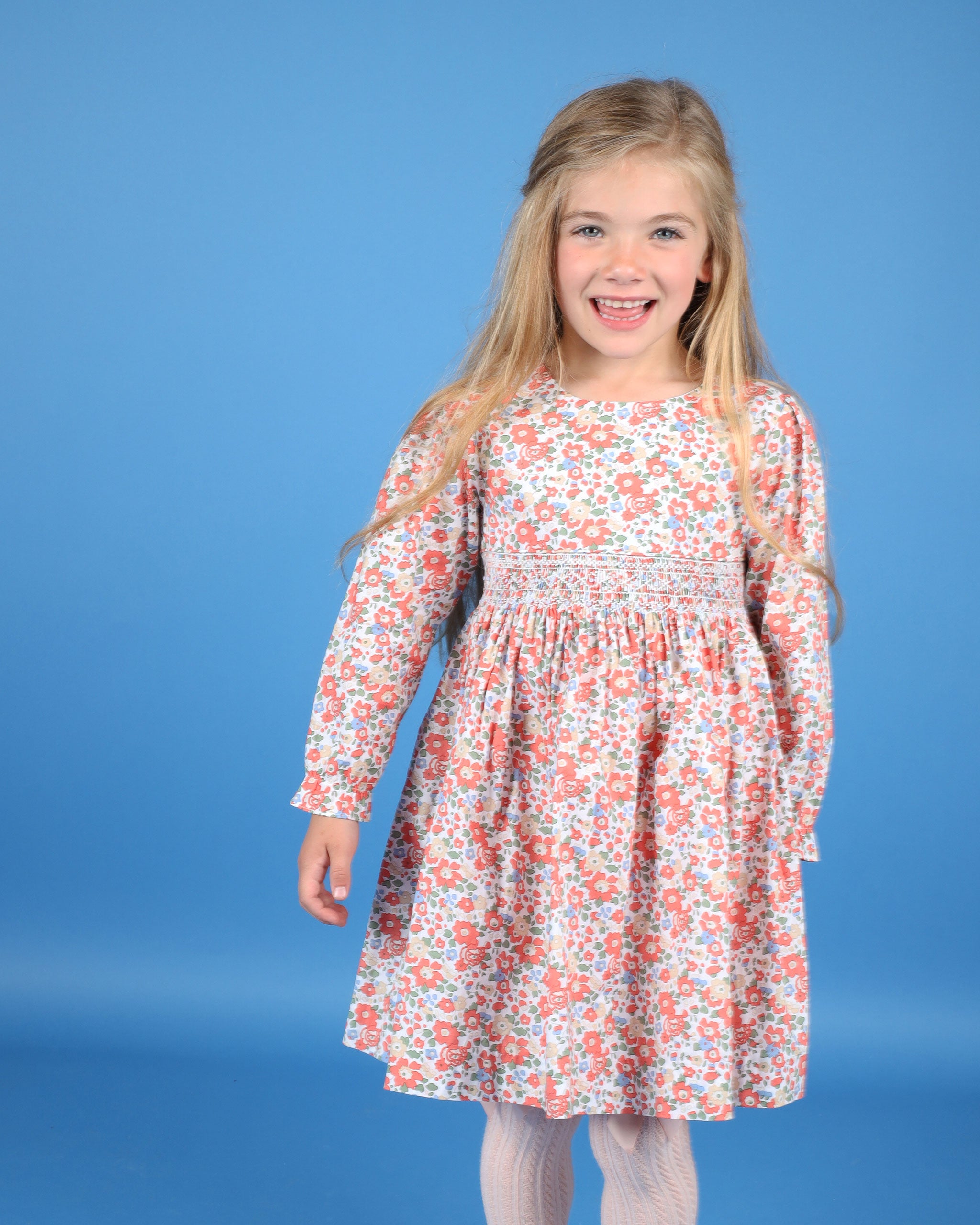 girl in red and beige floral smocked dress