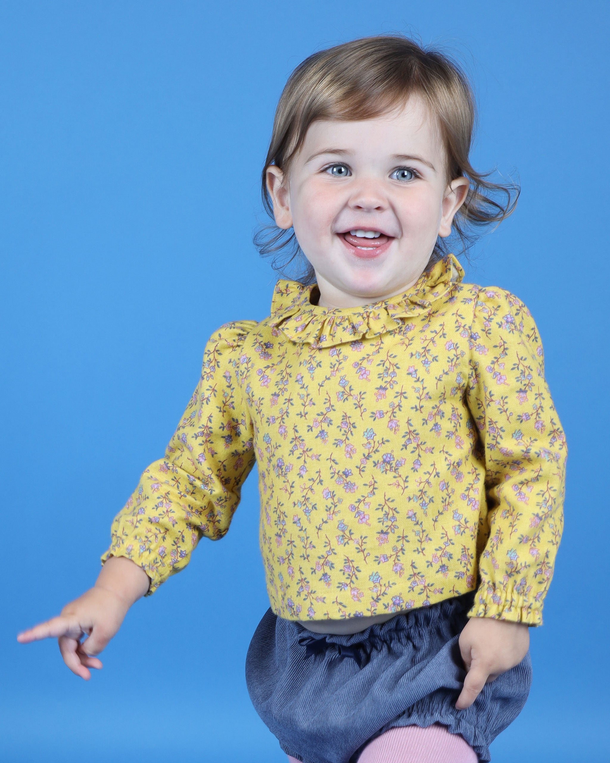 closeup of baby wearing yellow blouse with frill collar