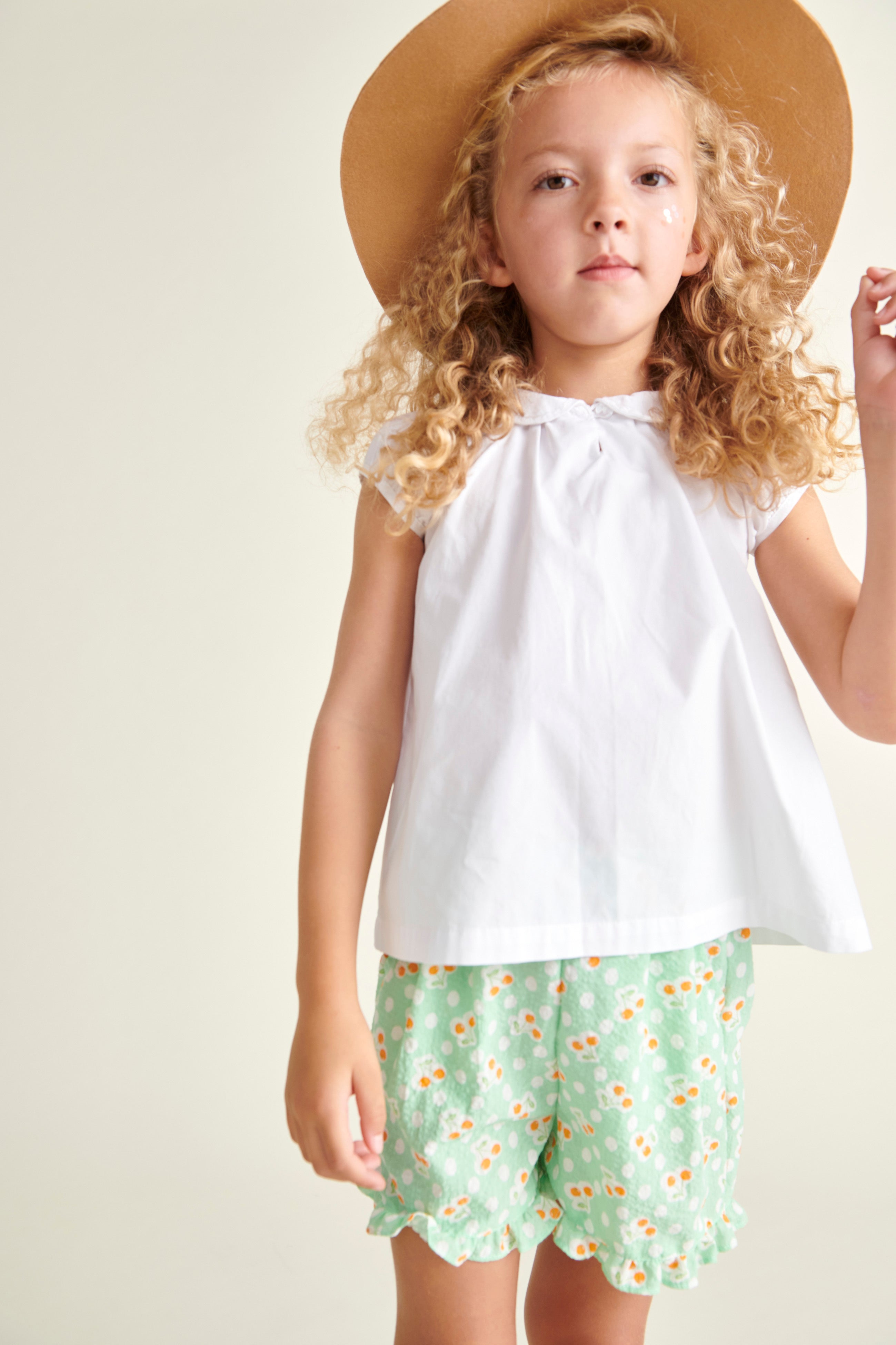 girl in white cotton blouse and shorts