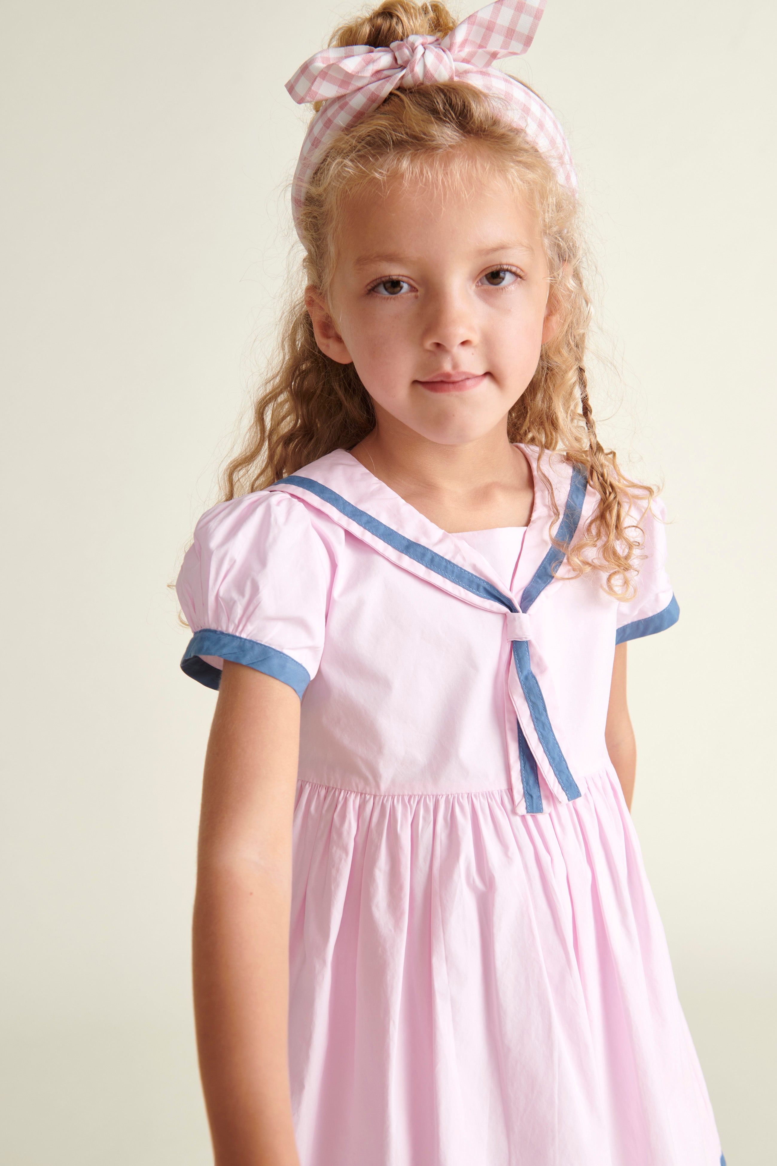 girl in sailor dress, pink and navy, closeup