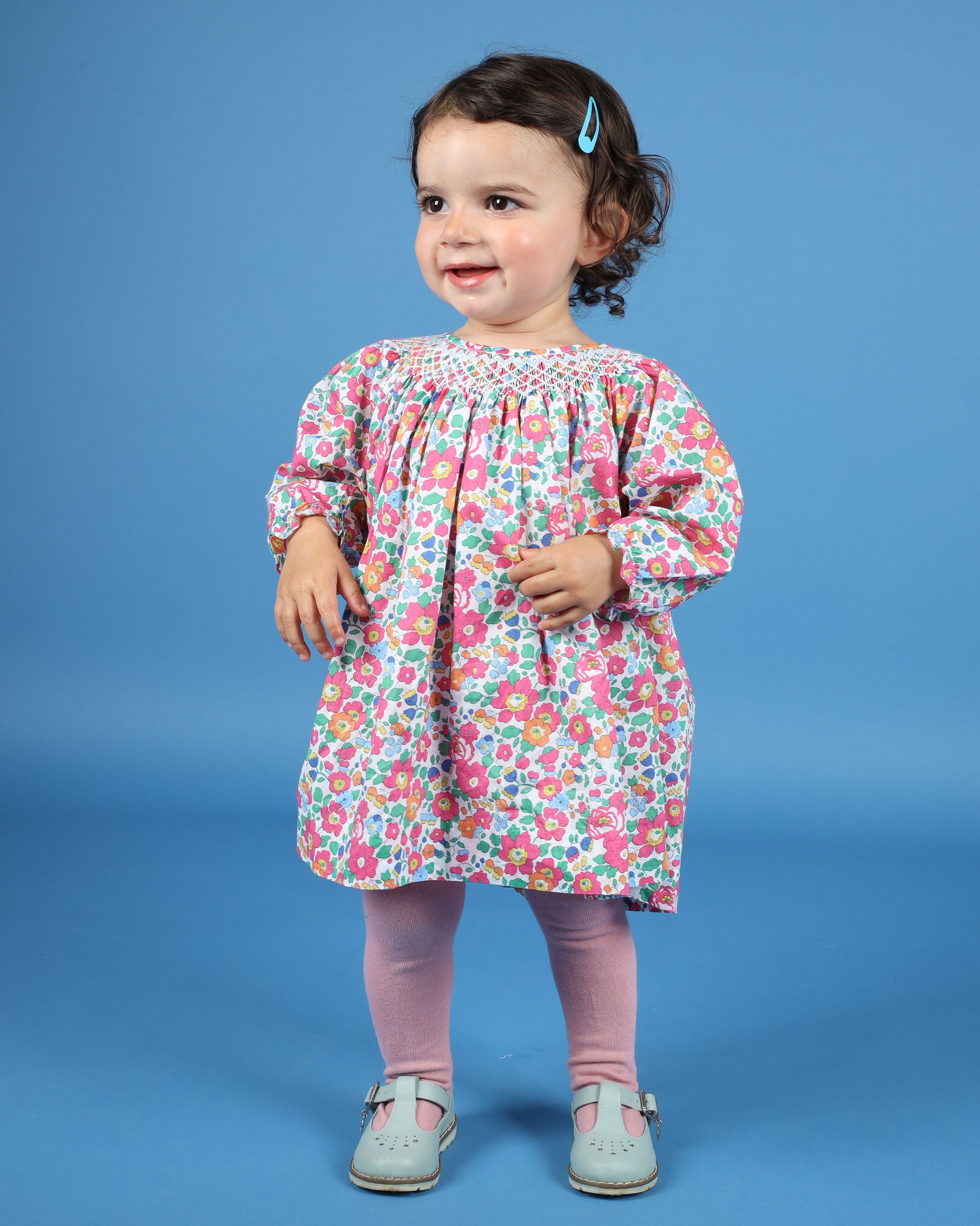 baby in Liberty fabric smocked dress with long sleeves