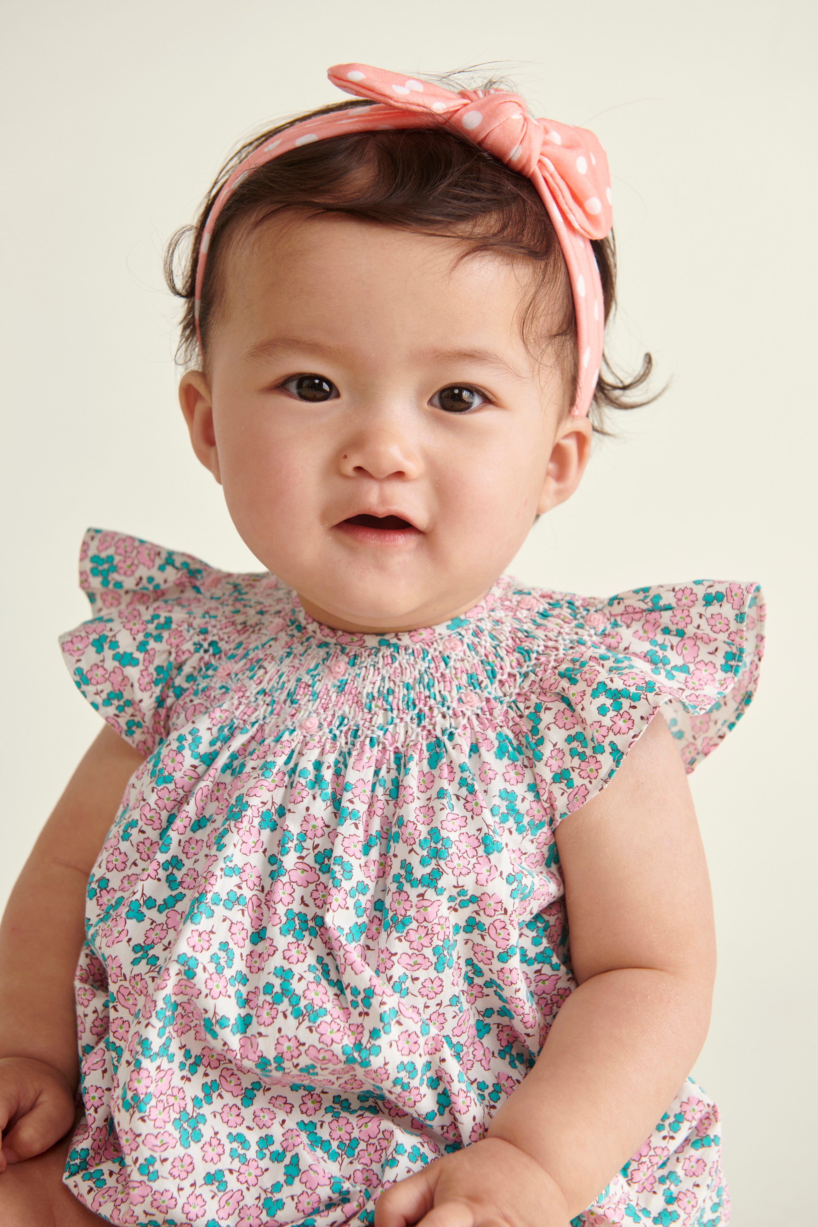 cute baby in frill-sleeve romper, hand-smocked