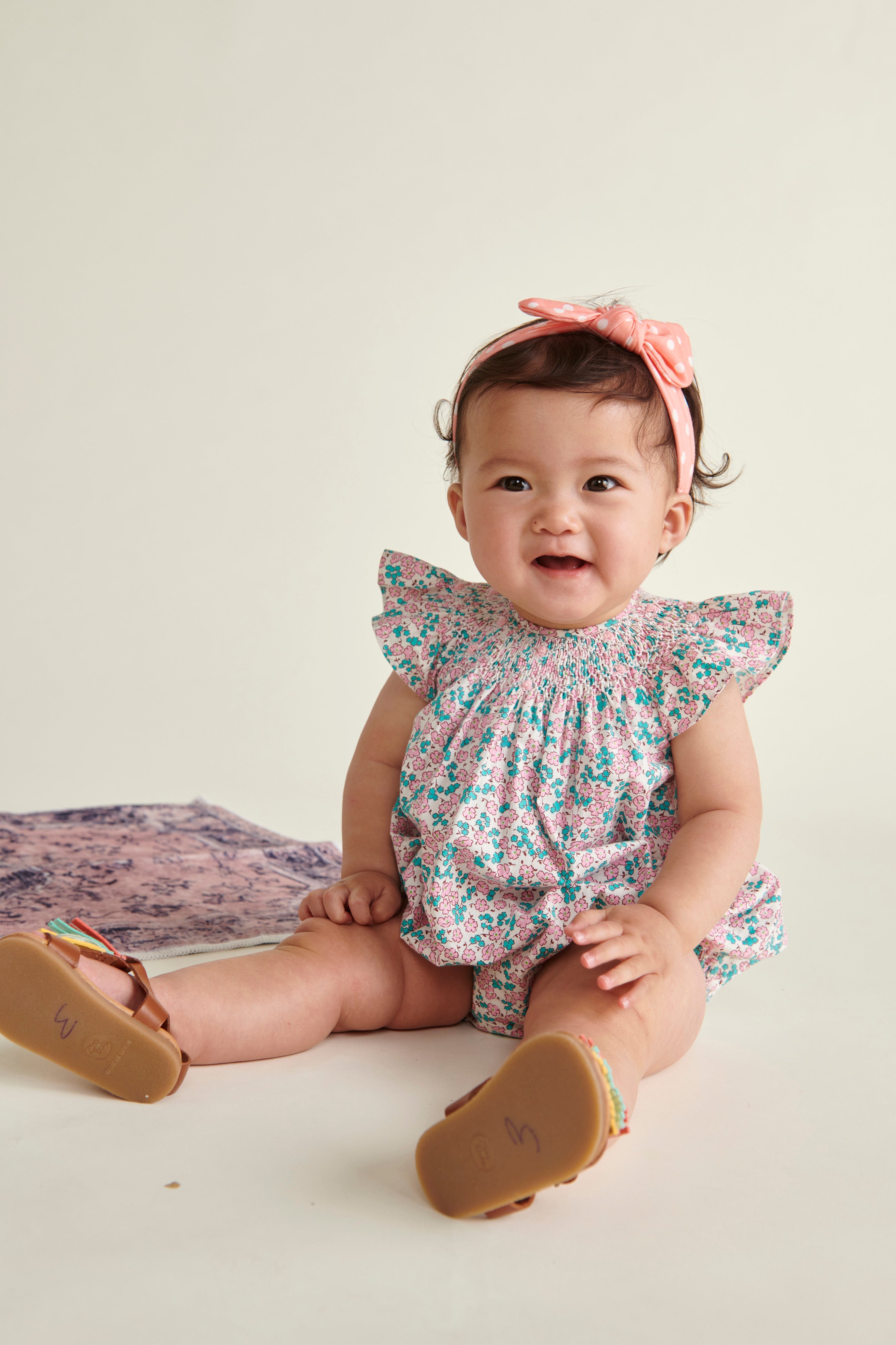 baby in pink on white floral  romper