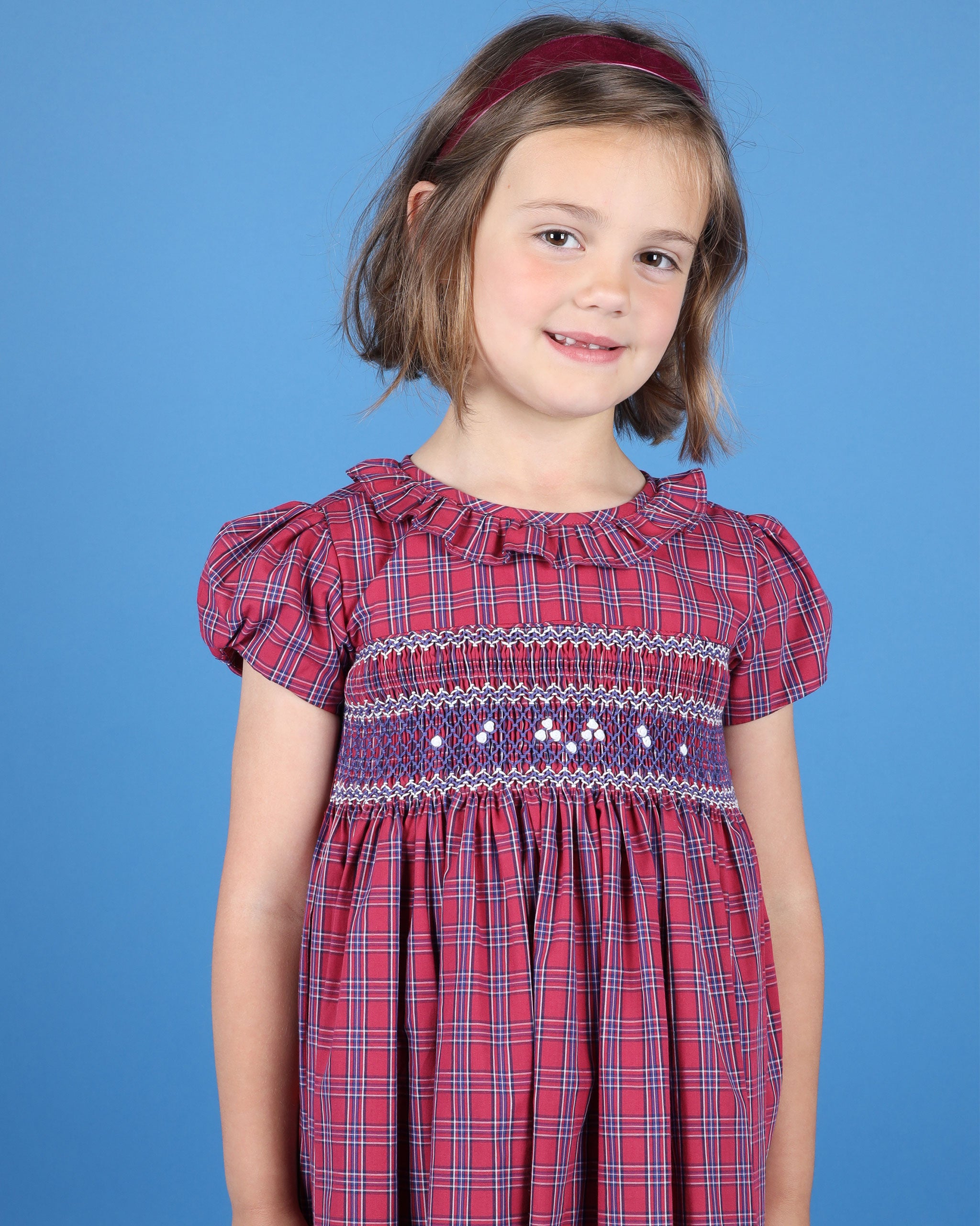 girl in festive tartan dress with frill collar