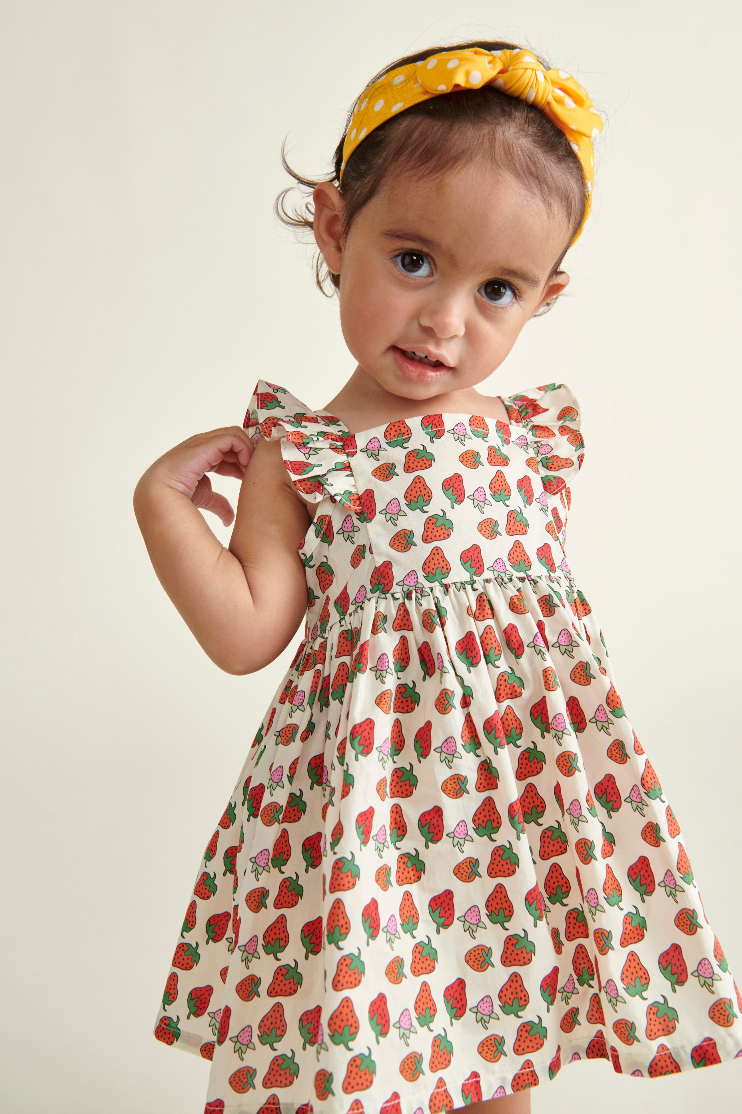 toddler girl i n Strawberry sun dress, closeup