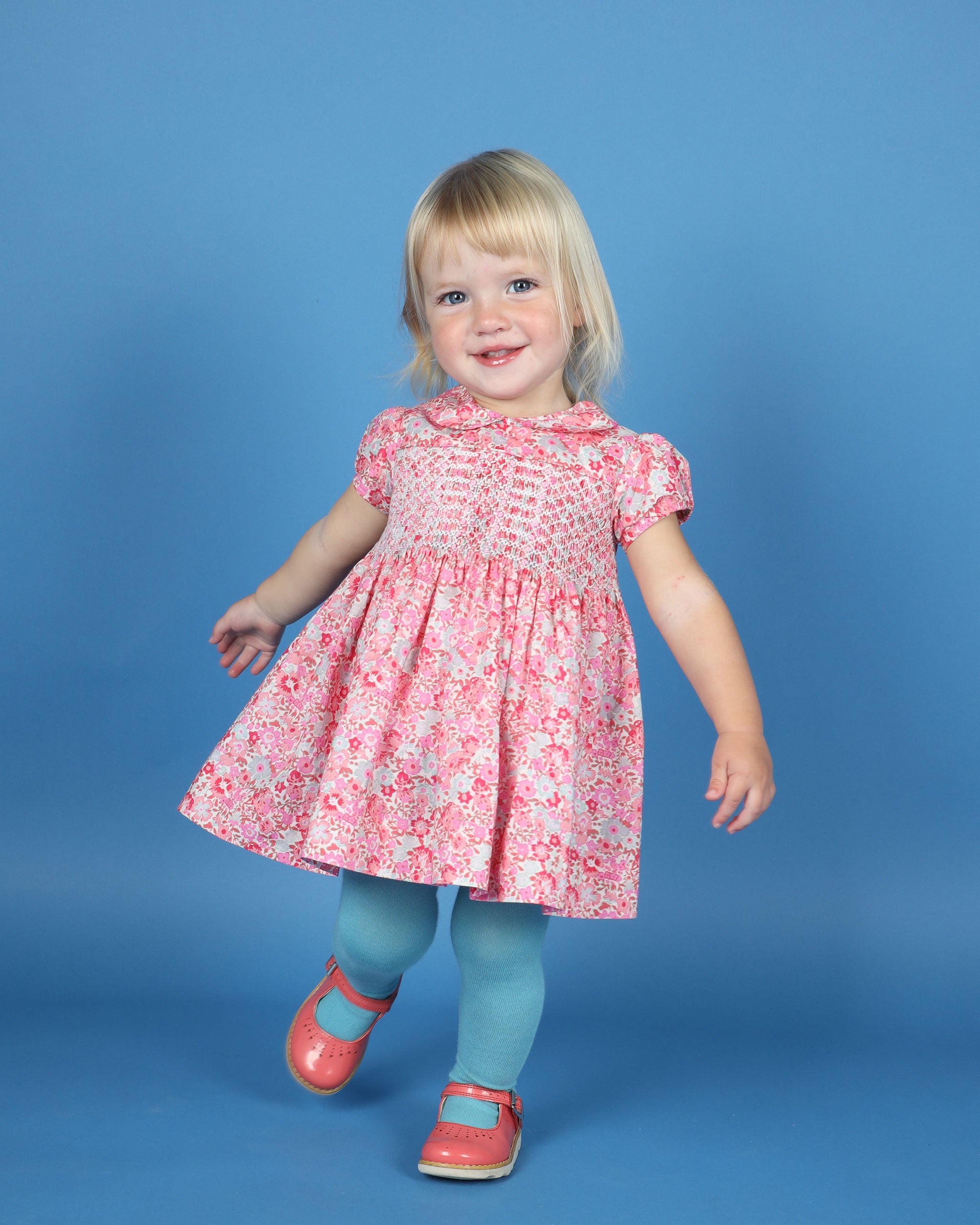 girl in  pink and red hand-smocked dress,