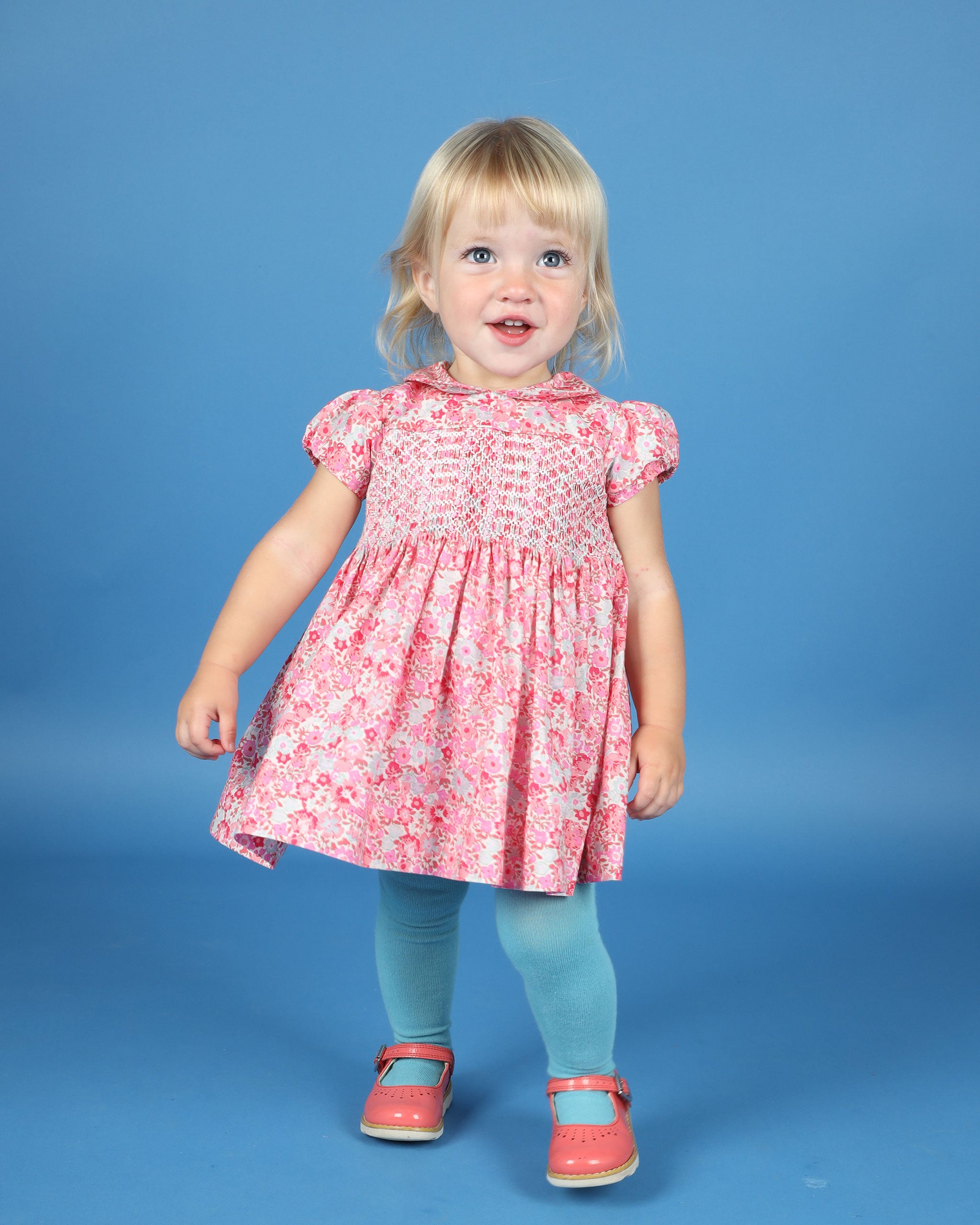 toddler girl wearing a hand-smocked dress made form pure cotton