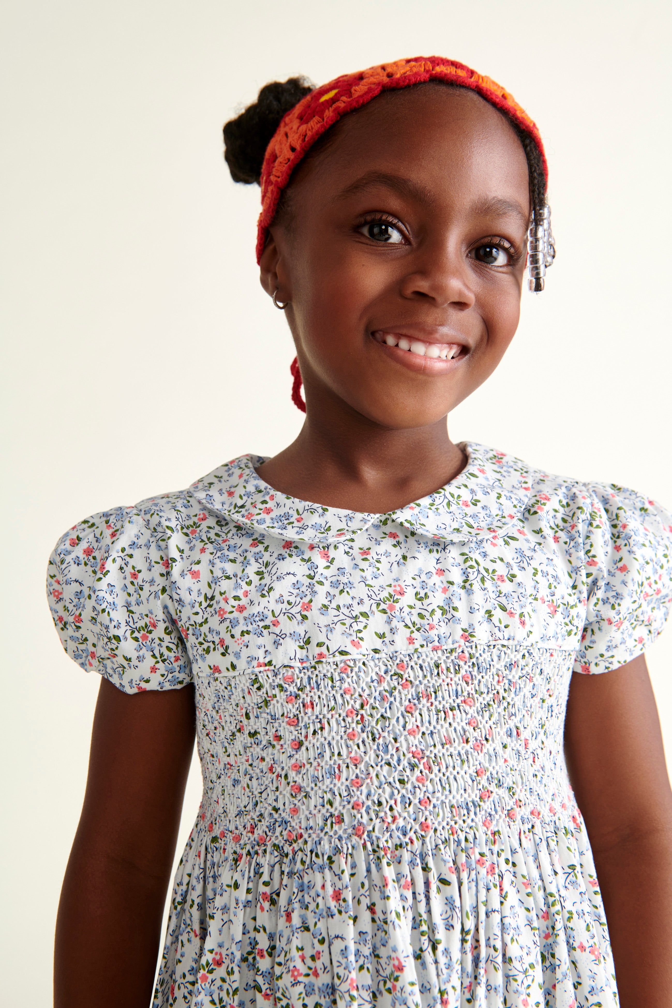 girl wearing a  ditsy floral white smoked dress, closeup