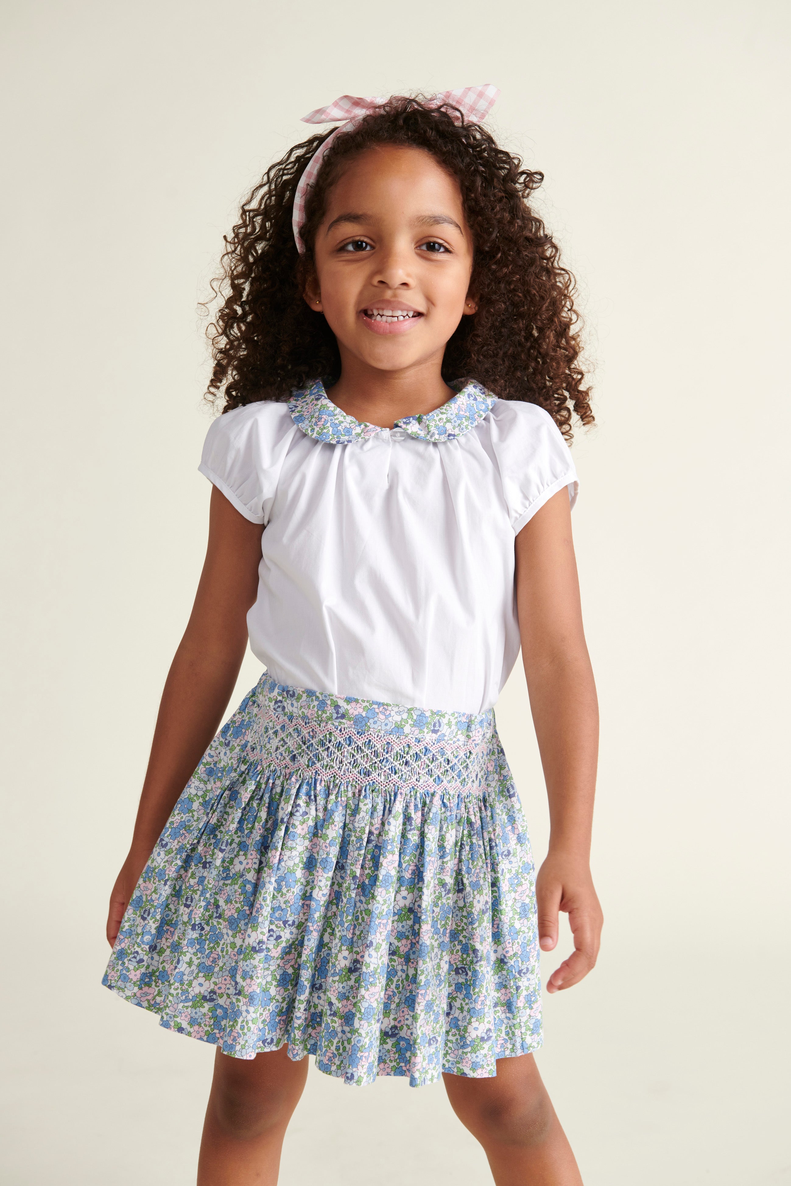 Girl in smocked skirt with matching blouse, blue floral