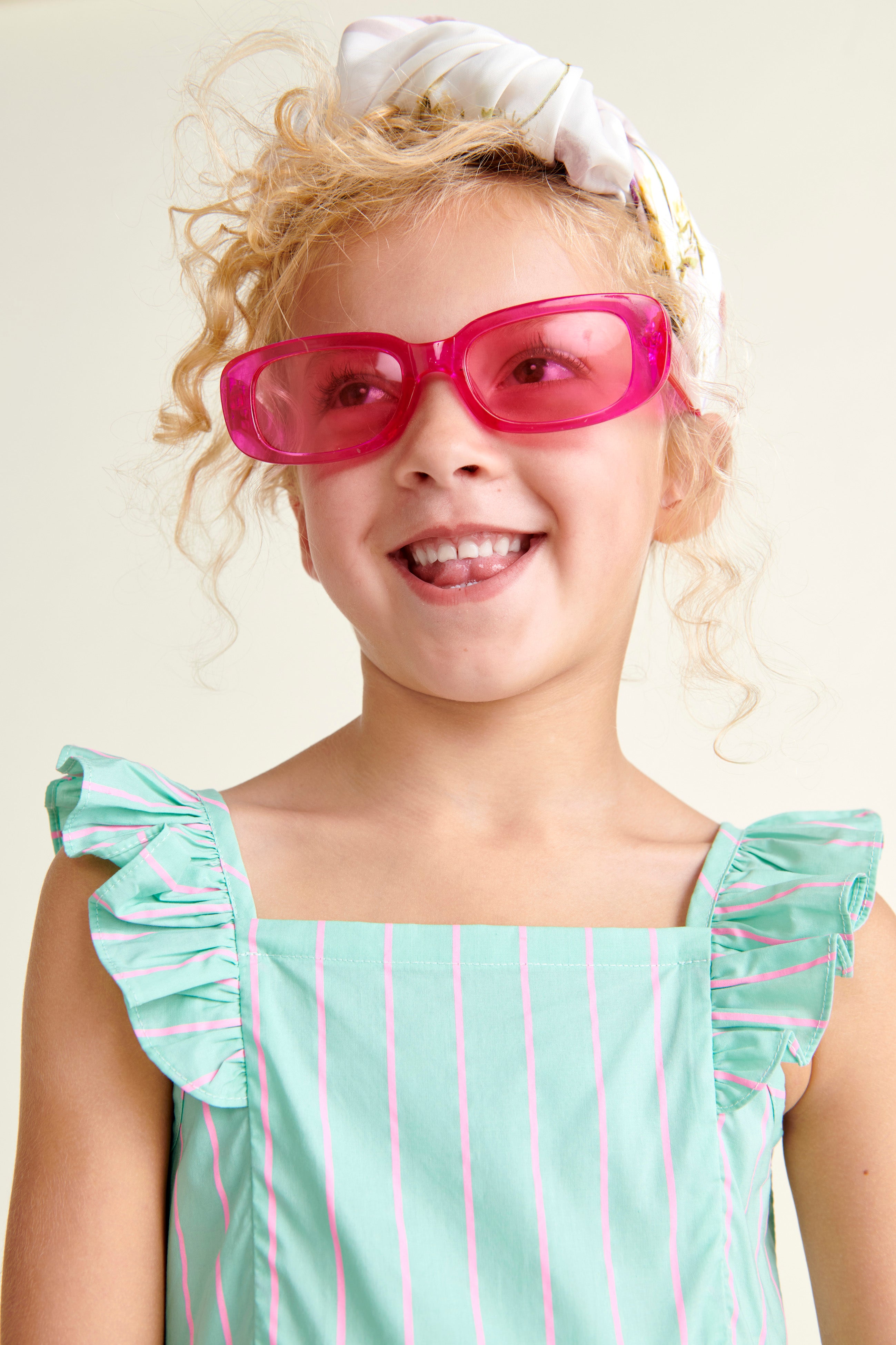 girl smiling and wearing mint green summer dress with pink stripes