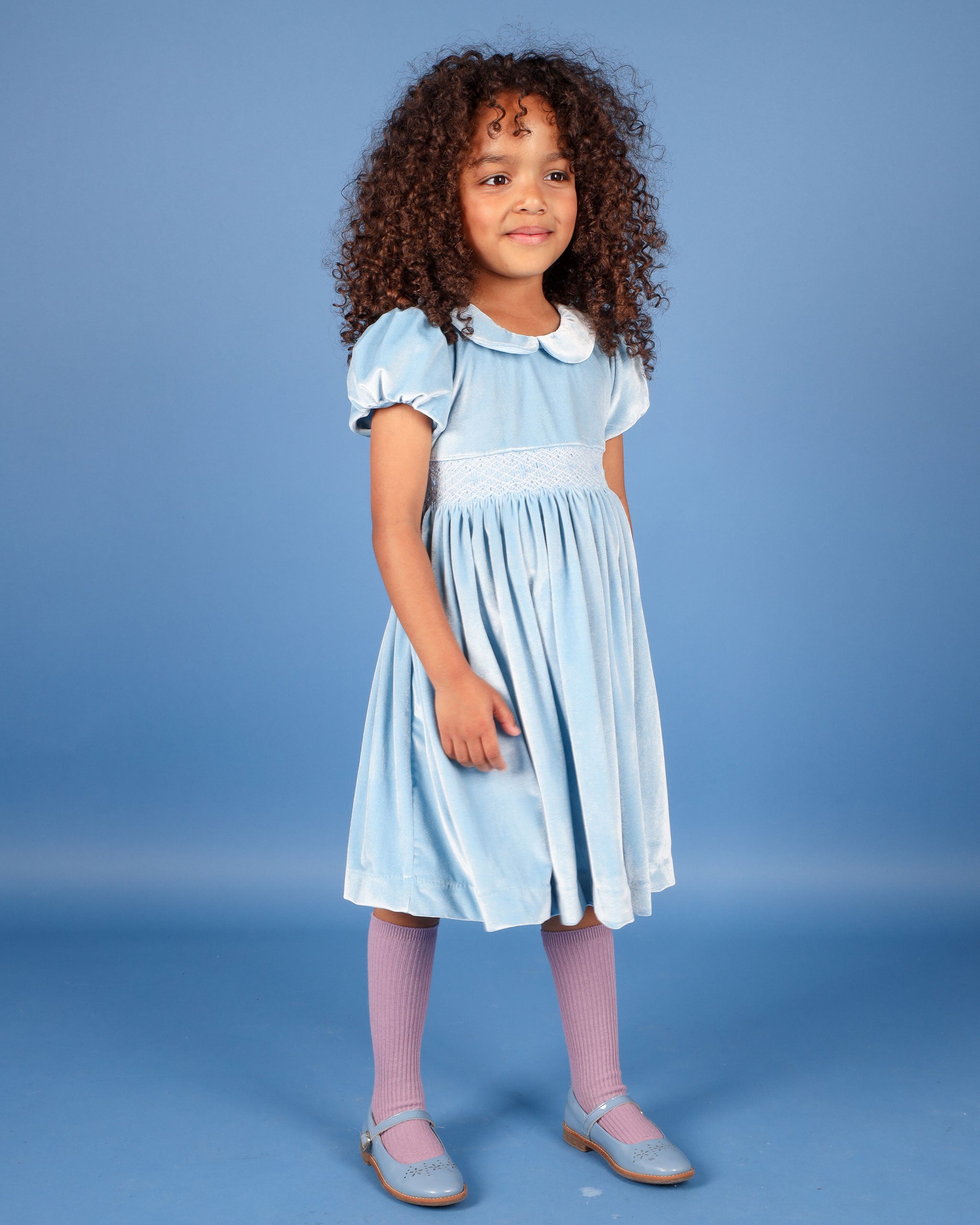 girl in pale blue velvet smock dress