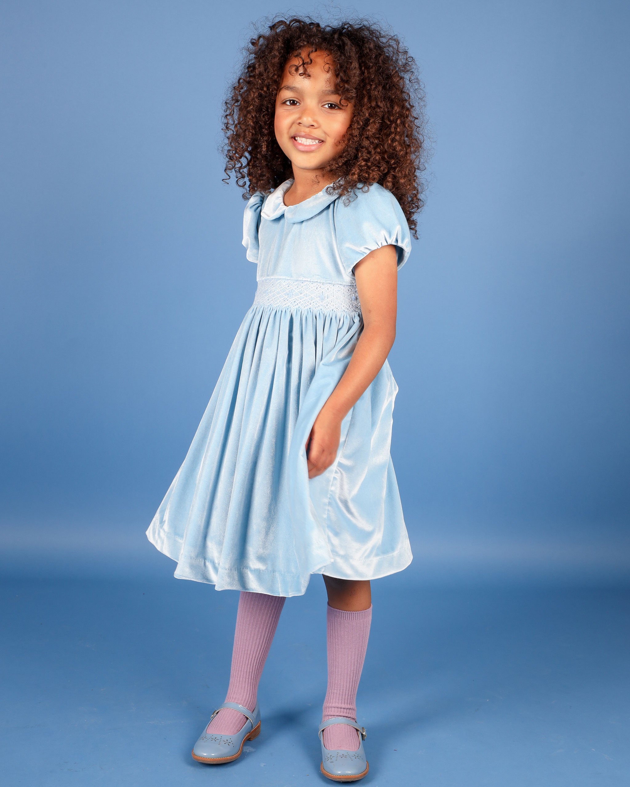 girl in smocked dress made from soft blue velvet