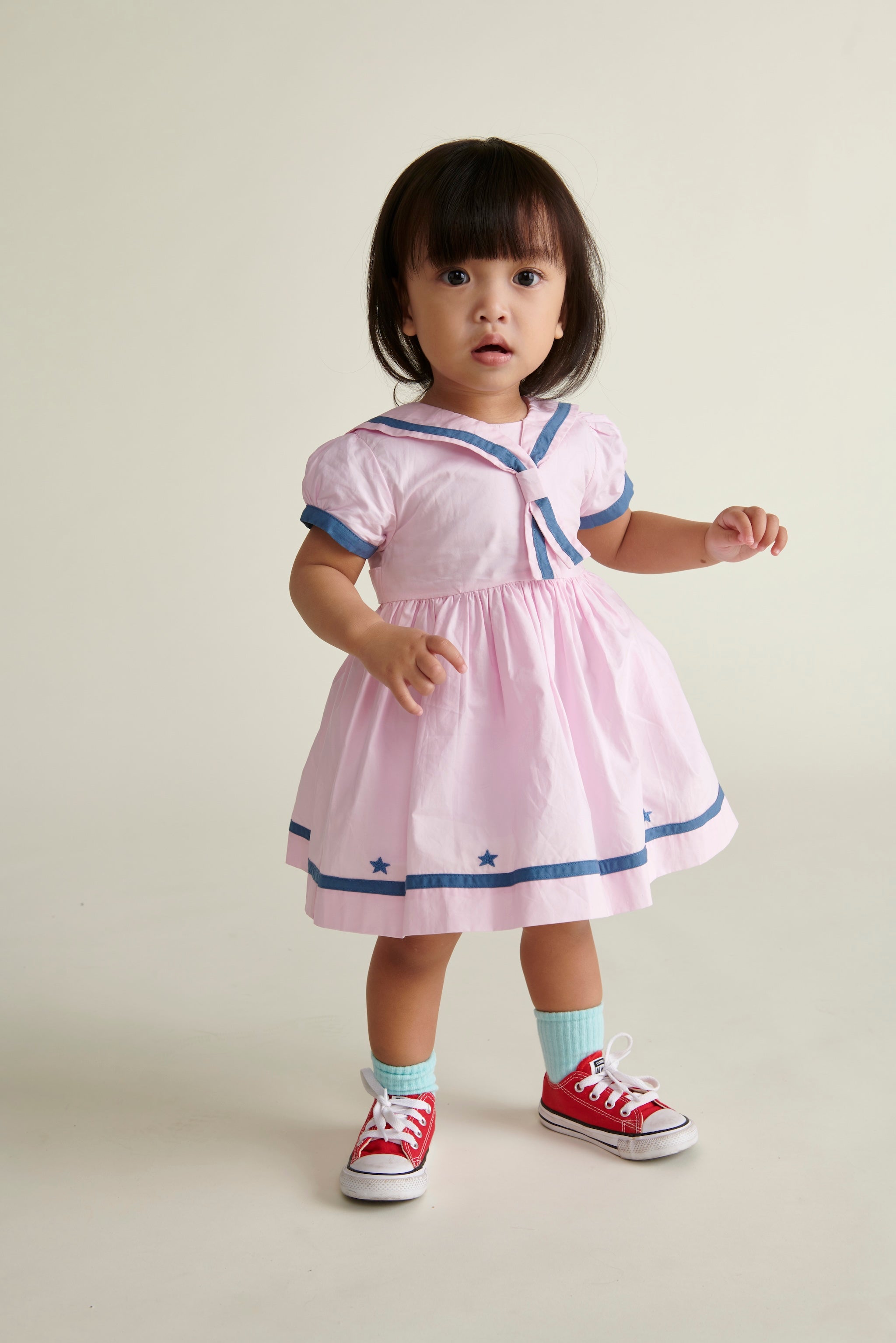 toddler girl in pink and navy sailor dress