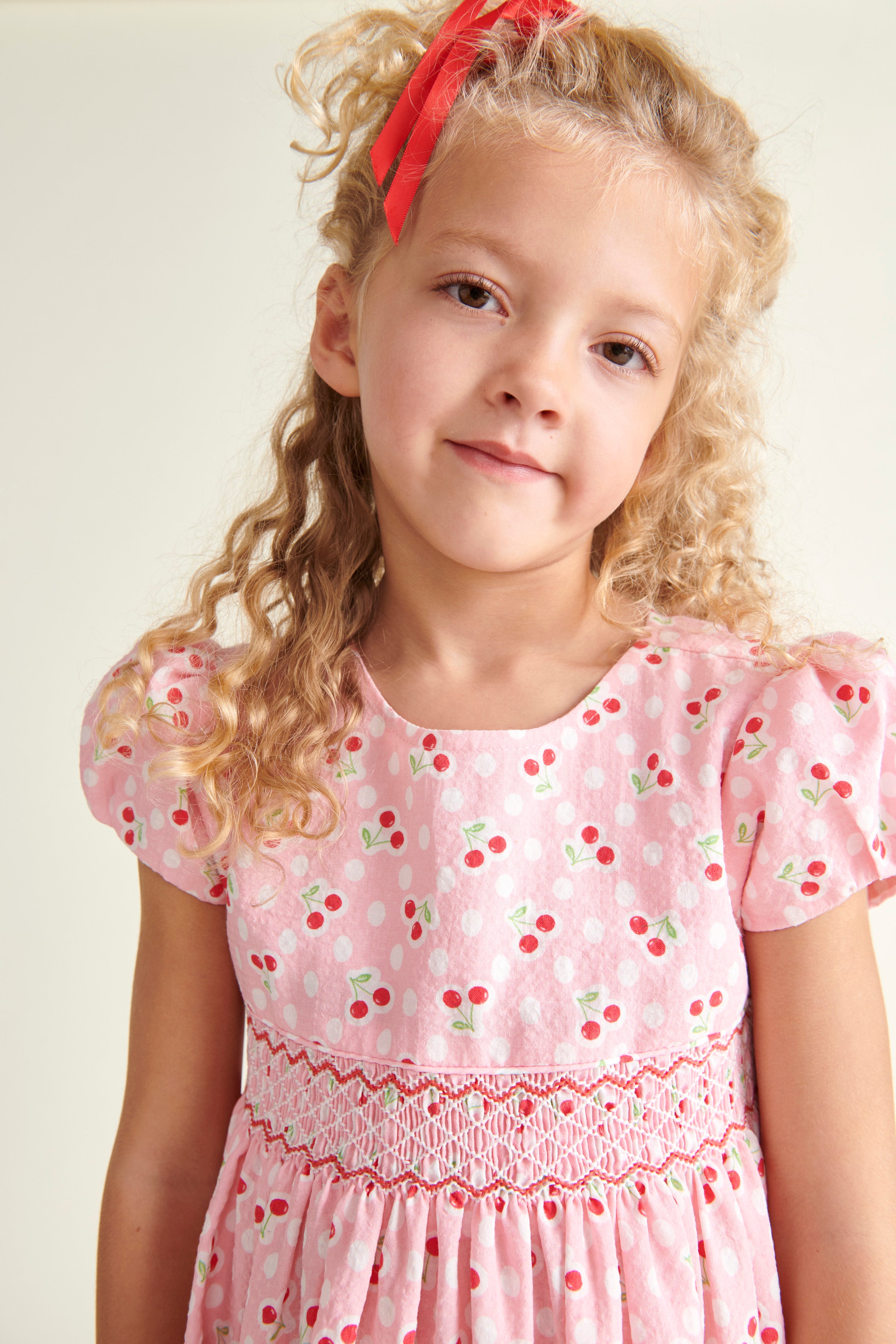 girl in pink cherry print dress, closeup