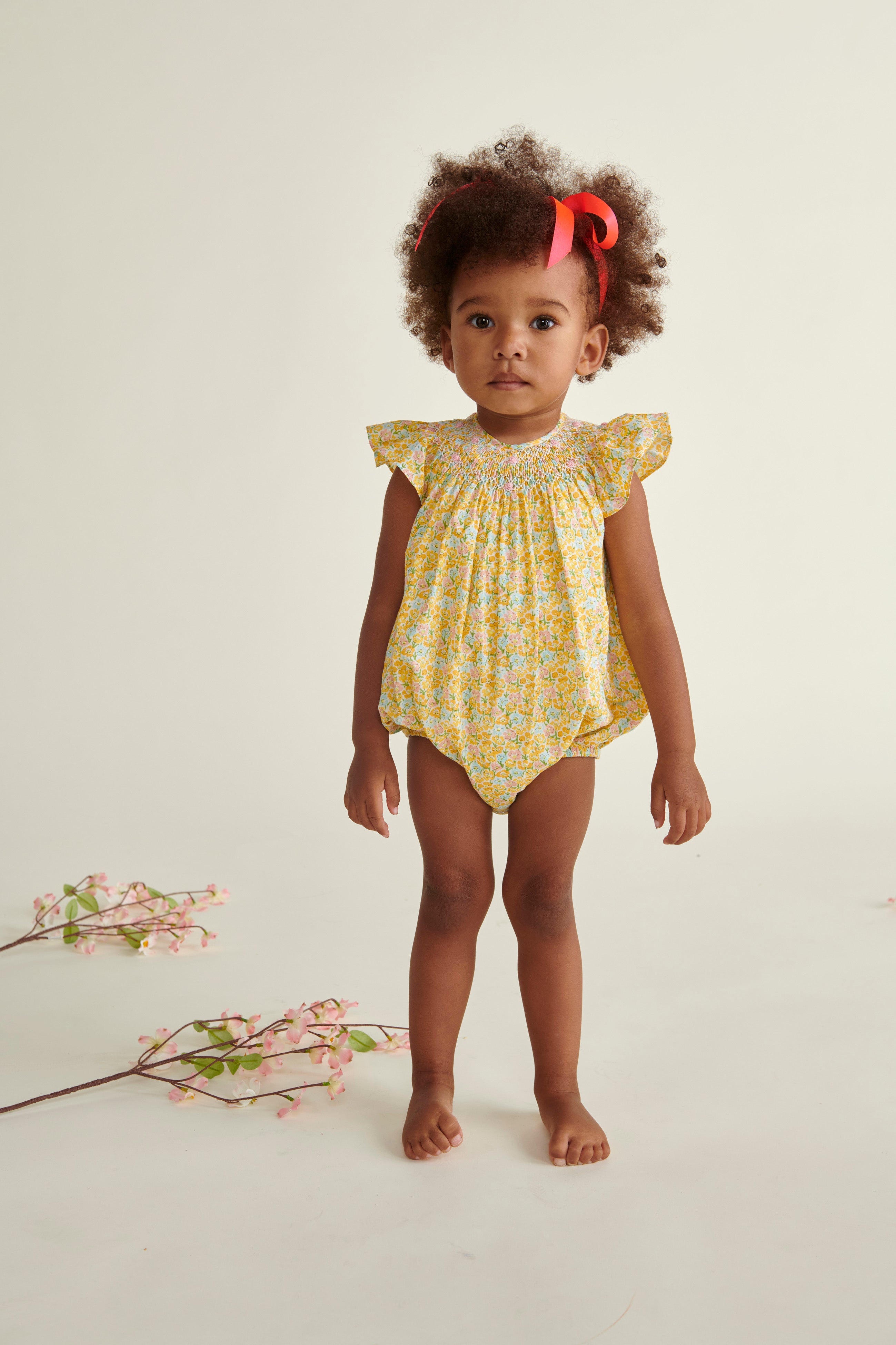 toddler in yellow hand-smocked romper
