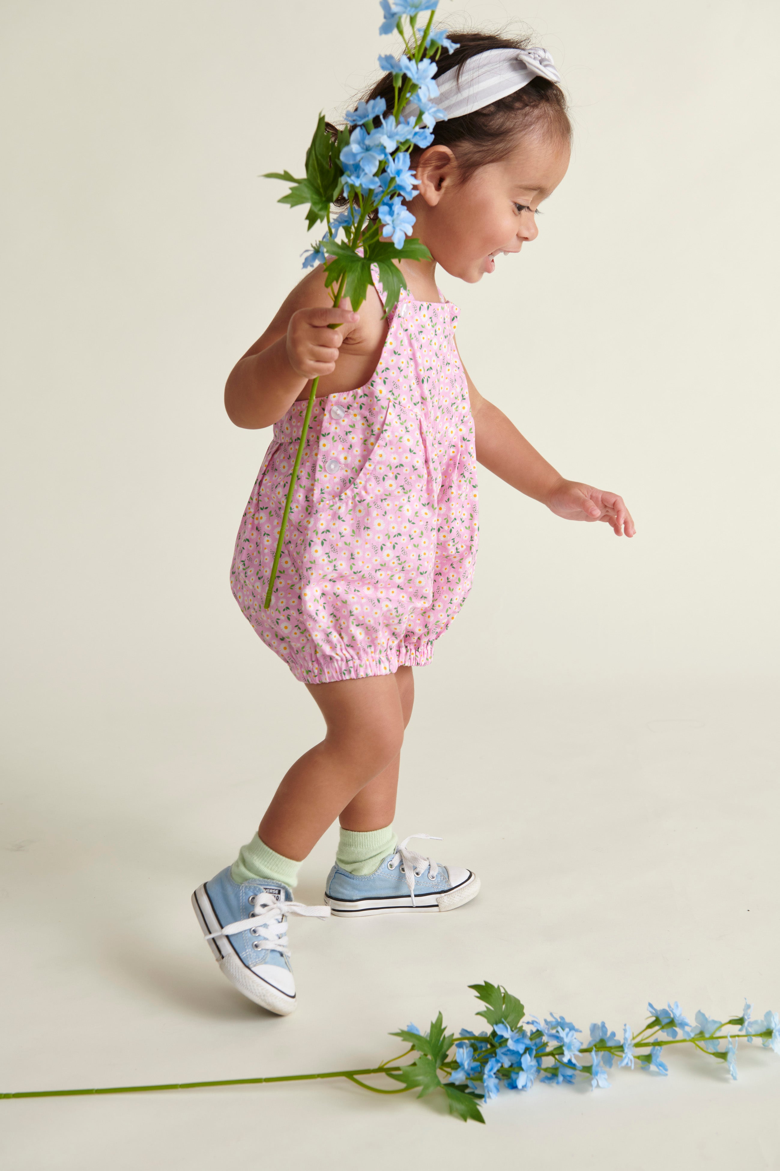 baby in pink daisy dungaree