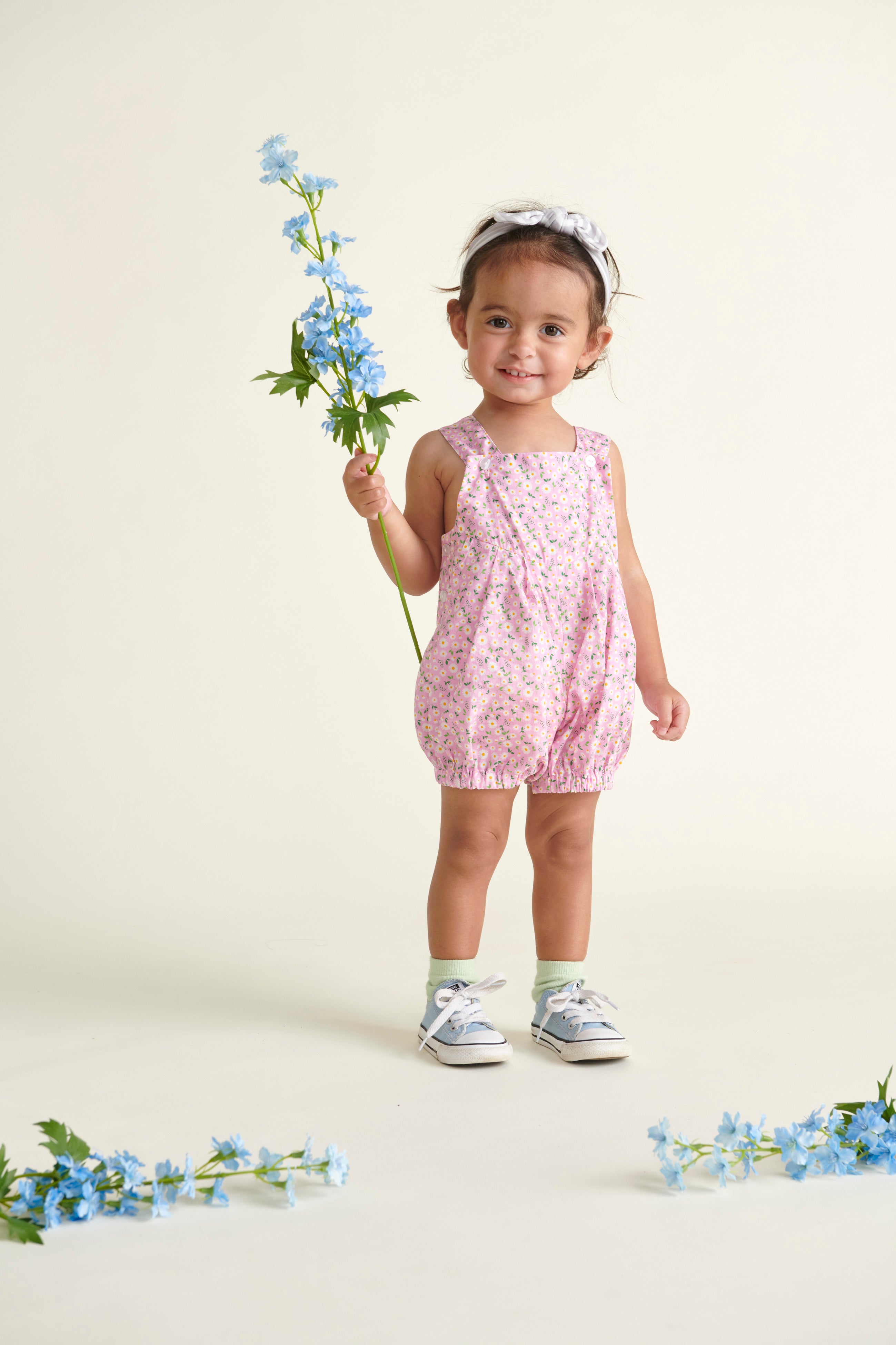 baby in pink daisy dungarees