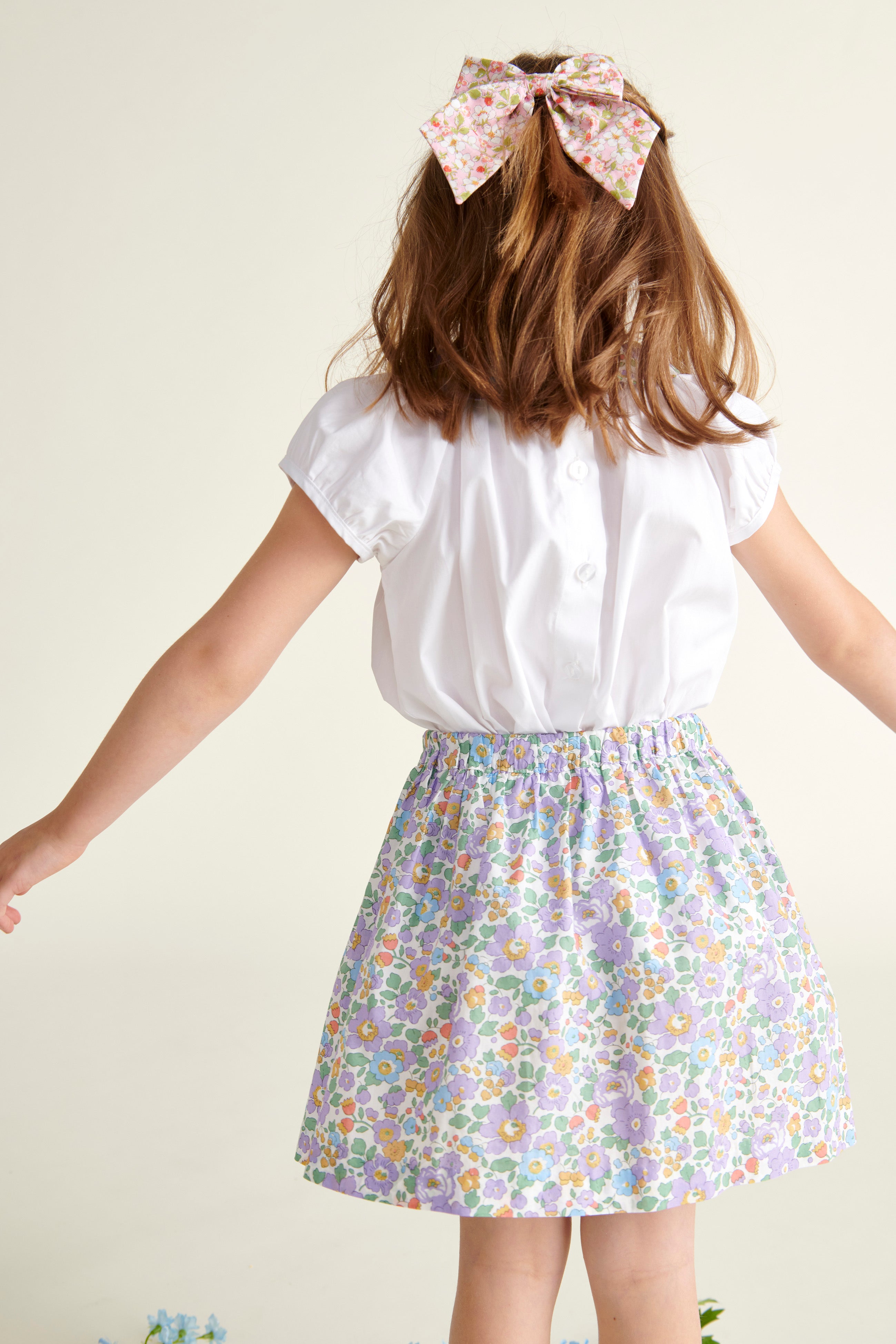 girl in summer skirt and blouse, from the back