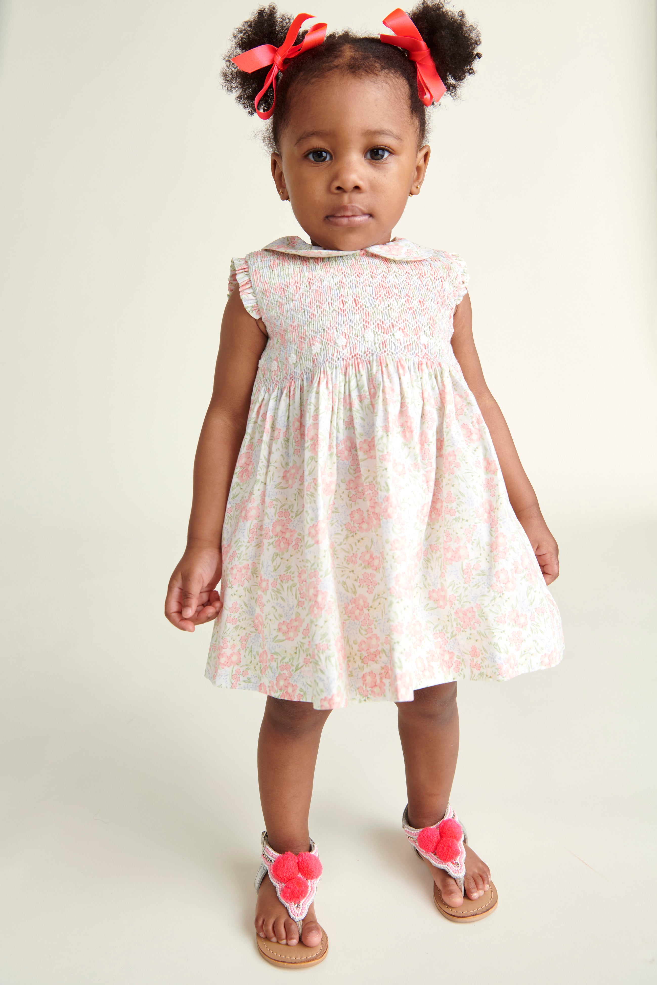 toddler girl in pastel colour smock dress