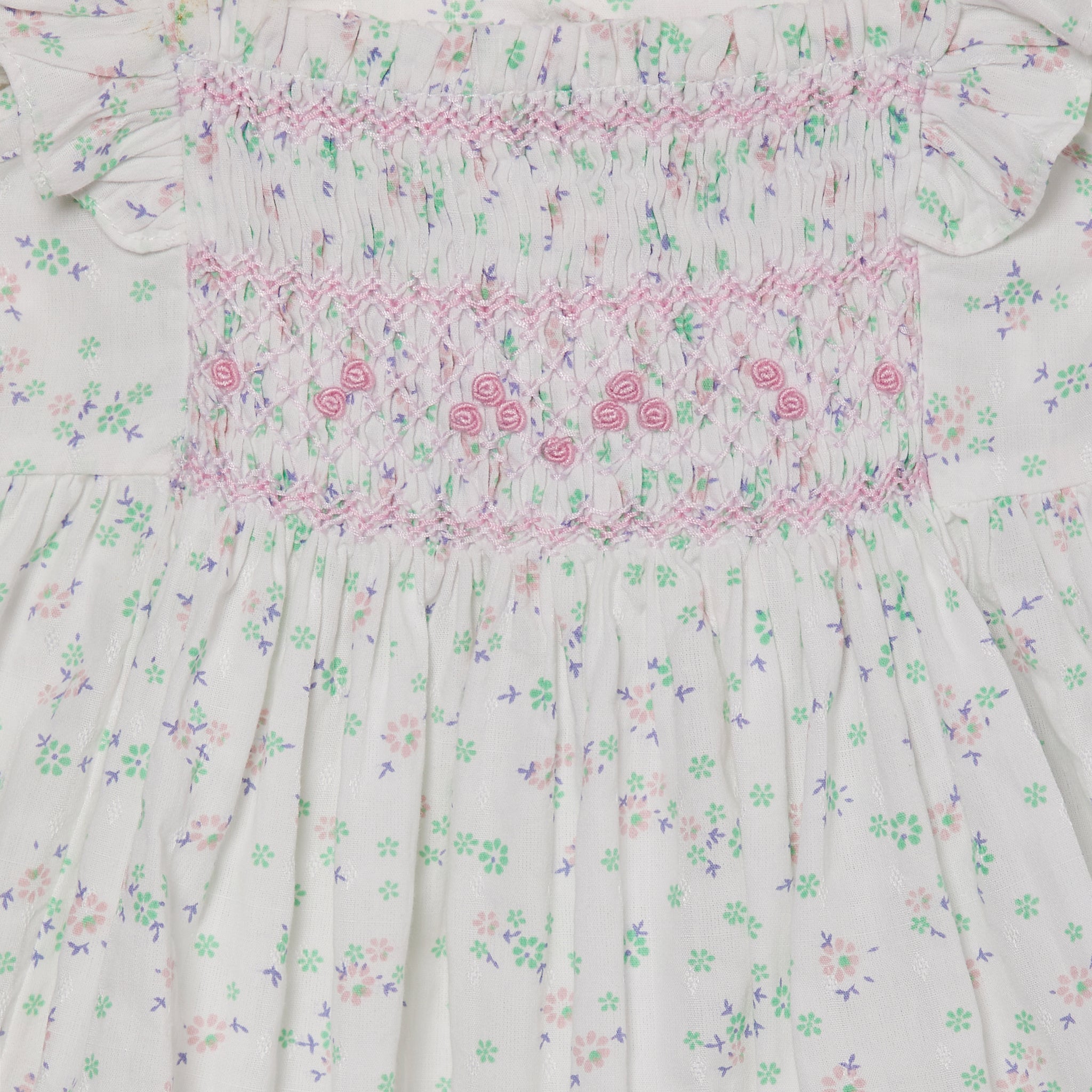 crisp white loral baby dress with smocking, detail shot