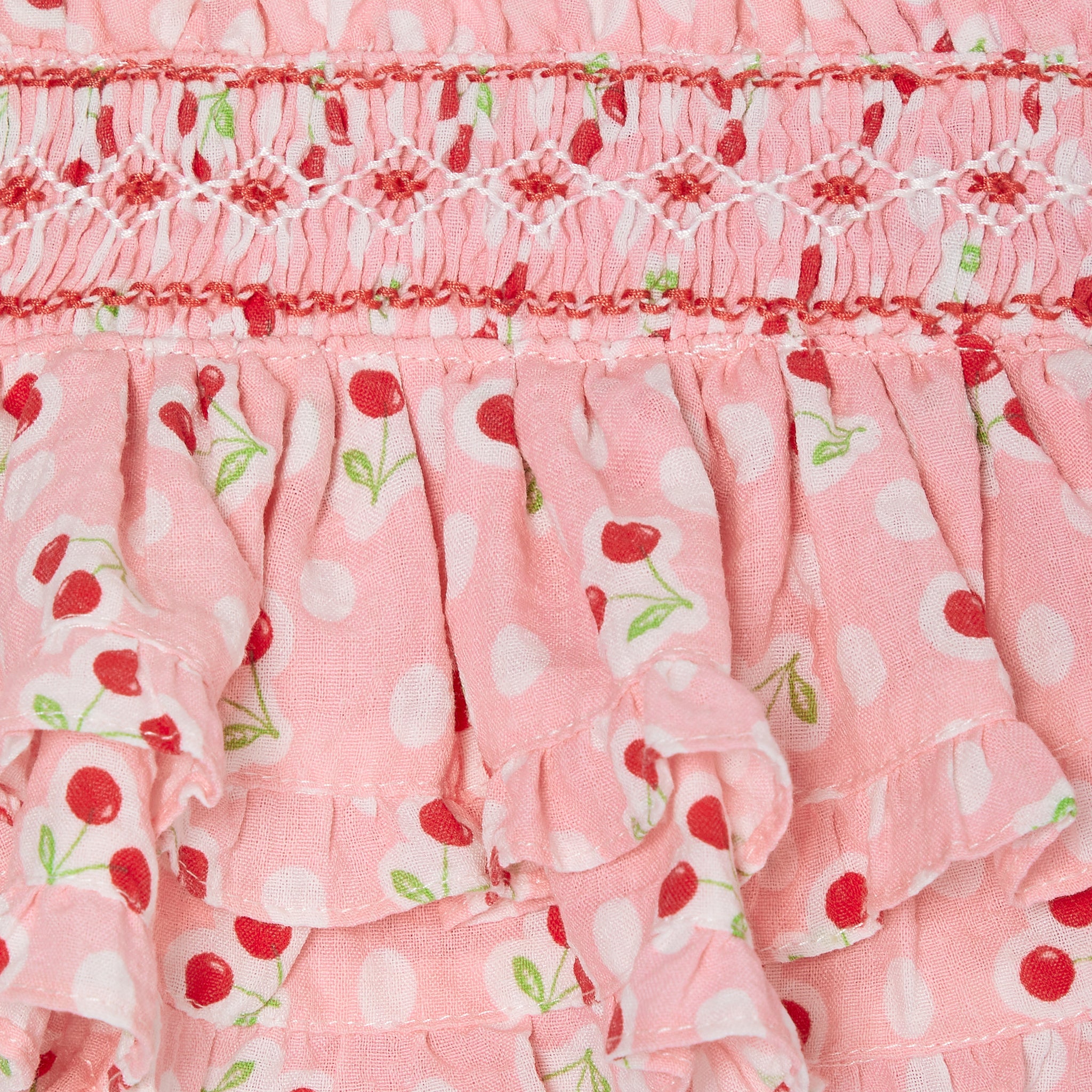 pink cherry print baby skort with smocking, closeup of smocking