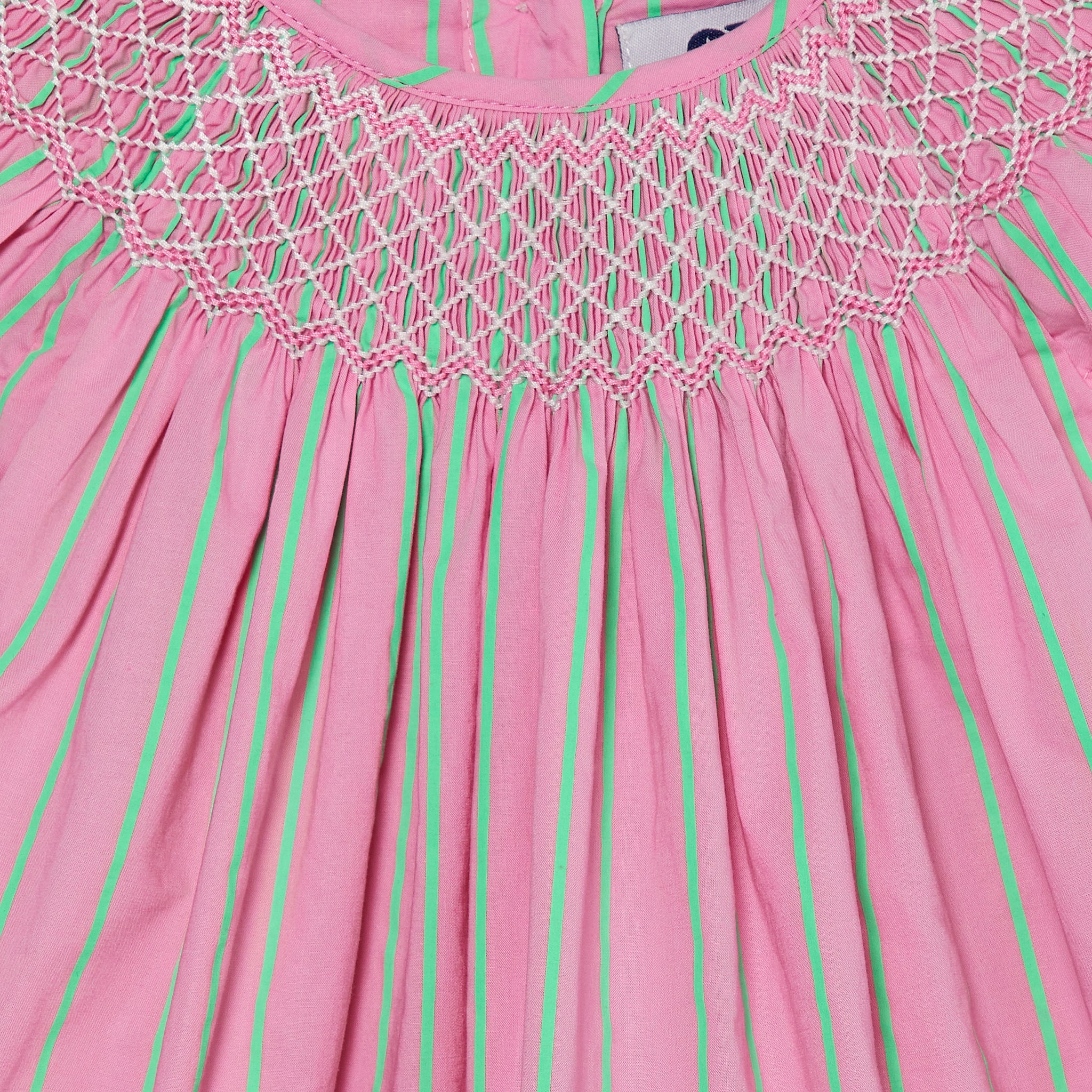 bright pink baby dress with stripes, smocking closeup